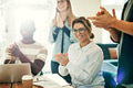 Smiling young woman clapping with colleagues in a modern office - PhotoDune Item for Sale