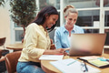Laughing young businesswomen using a laptop in an office lounge - PhotoDune Item for Sale