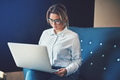 Young businesswoman sitting on a sofa working online - PhotoDune Item for Sale