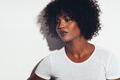 Stylish young African woman standing against a white background - PhotoDune Item for Sale