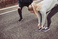 Young woman tying her running shoes before a jog - PhotoDune Item for Sale