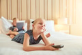 Smiling little girl watching television on a bed - PhotoDune Item for Sale