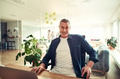Smiling mature businessman sitting at his desk in an office - PhotoDune Item for Sale