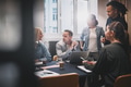 Businesspeople going over work together during an office meeting - PhotoDune Item for Sale
