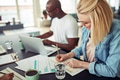 Smiling young businesswoman working with colleagues at an office table - PhotoDune Item for Sale
