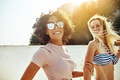 Smiling friends walking together along a sandy beach - PhotoDune Item for Sale