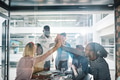 Laughing businesspeople high fiving together inside a glass walled boardroom - PhotoDune Item for Sale