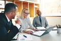 Three laughing businesspeople discussing paperwork together in an office - PhotoDune Item for Sale