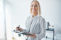 Smiling young businesswoman writing notes while working in an office - PhotoDune Item for Sale