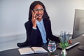 African American businesswoman talking on a cellphone at her desk - PhotoDune Item for Sale