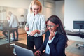 Laughing businesswomen looking at something on a laptop at work - PhotoDune Item for Sale
