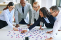 Diverse group of businesspeople working together to solve a puzzle - PhotoDune Item for Sale