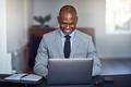 Smiling African American businessman using a laptop at work - PhotoDune Item for Sale
