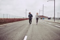 Young couple in sportswear running along a road together - PhotoDune Item for Sale