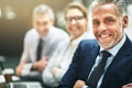 Smiling mature businessman sitting with colleagues at an office table - PhotoDune Item for Sale