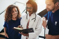 Smiling group of diverse doctors talking together in a hospital - PhotoDune Item for Sale