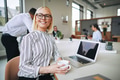 Smiling young businesswoman sitting in an office boardroom drinking coffee - PhotoDune Item for Sale