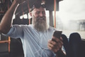 Mature man listening to music and laughing on a bus - PhotoDune Item for Sale