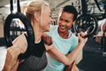 Laughing female friends working out with rings at the gym - PhotoDune Item for Sale