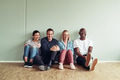 Diverse businesspeople laughing together while sitting on an office floor - PhotoDune Item for Sale