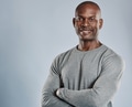 Cheerful black man with folded arms in gray - PhotoDune Item for Sale
