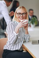 Smiling young businesswoman sitting at work drinking a coffee - PhotoDune Item for Sale