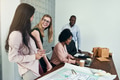 Smiling businesspeople talking around a table in an office - PhotoDune Item for Sale