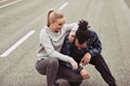 Laughing young couple kneeling on a road while out jogging - PhotoDune Item for Sale