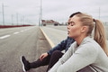 Young couple sitting on a curb after jogging together - PhotoDune Item for Sale