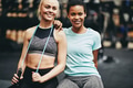 Smiling gym friends sitting together after a workout - PhotoDune Item for Sale