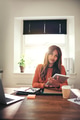 Confident young woman using a tablet in her home office - PhotoDune Item for Sale