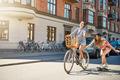 Cute girl on bike pulling friend on skateboard - PhotoDune Item for Sale