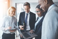 Diverse businesspeople smiling while using a laptop in an office - PhotoDune Item for Sale
