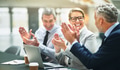 Smiling mature businesspeople clapping together during an office meeting - PhotoDune Item for Sale