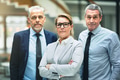 Confident mature businesswoman and two colleagues standing in an office - PhotoDune Item for Sale