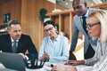 Diverse businesspeople going over paperwork together during an office meeeting - PhotoDune Item for Sale