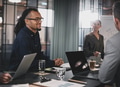 Smiling young businessman meeting with coworkers in an office - PhotoDune Item for Sale