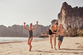 Laughing Mother and her adorable children running along a beach - PhotoDune Item for Sale