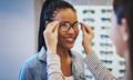 Attractive young African woman selecting glasses - PhotoDune Item for Sale