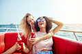 Two laughing girlfriends having drinks together on a boat - PhotoDune Item for Sale