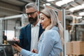 Female engineer and male supervisor standing in modern industrial factory, talking about production - PhotoDune Item for Sale