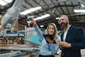 Female engineer and male project manager standing in modern industrial factory by precision robotic - PhotoDune Item for Sale