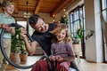 Father and son vacuuming girl's hair with vacuum cleaner. Father with kids cleaning house, helping - PhotoDune Item for Sale