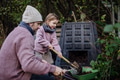 Girl helping father to remove compost from a composter in garden. Concept of composting and - PhotoDune Item for Sale