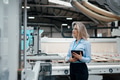 Female engineer in modern industrial factory, checking robotic arm, controling process and - PhotoDune Item for Sale