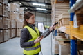 Female warehouse worker holding scanner, scanning the barcodes on products in warehouse. Warehouse - PhotoDune Item for Sale