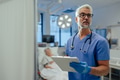 Portrait of handsome male doctor, patient in hospital bed behind. ER doctor examining senior patient - PhotoDune Item for Sale