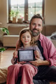 Father and girl holding smart thermostat, adjusting, lowering heating temperature at home. Concept - PhotoDune Item for Sale