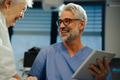 Portrait of handsome mature doctor talking with elderly patient in hospital. Consulting medical test - PhotoDune Item for Sale