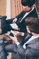 two elegant businessmen sitting bench outdoors using tablet and smartphone - PhotoDune Item for Sale